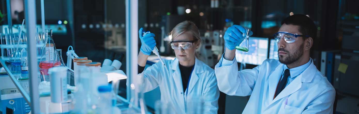 two people in a lab with googles on looking at something