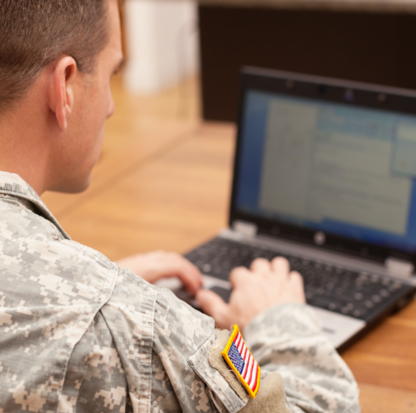 Man in military uniform at a computer