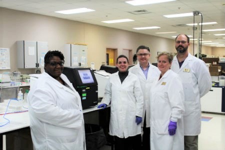 Alamance Community College biotech specialists pose with illumina device