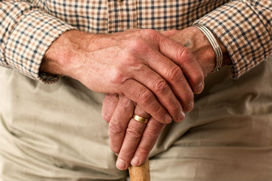 Elderly man's hands on a cane
