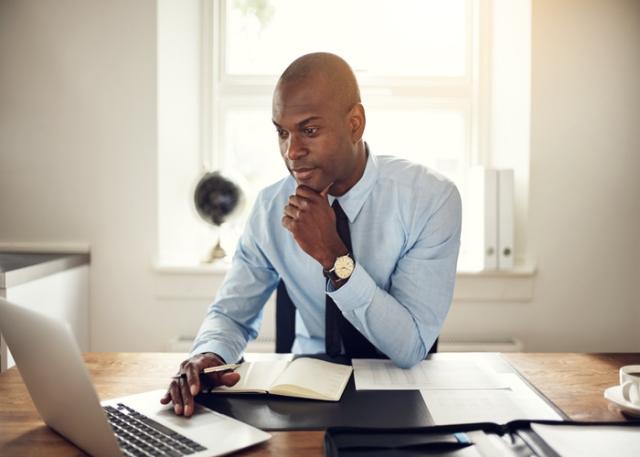 Black man searching for a job on a laptop